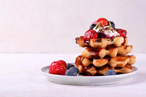 Stack of waffles with berries, whipped cream and chocolate sauce Stock-Fotos
