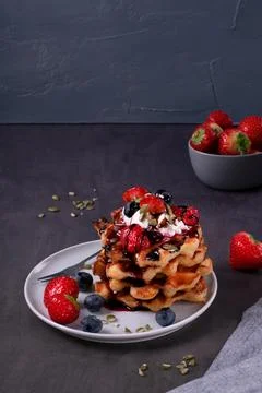 Stack of waffles with berries, whipped cream and chocolate sauce Foto stock