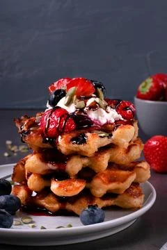 Stack of waffles with berries, whipped cream and chocolate sauce Stock-Fotos