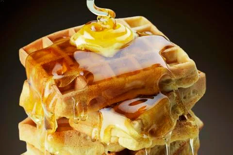 A stack of waffles with butter and dripping honey 스톡 사진