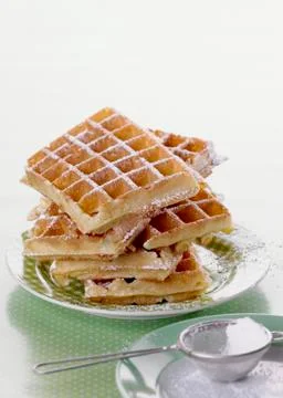 A stack of waffles dusted with icing sugar 스톡 사진