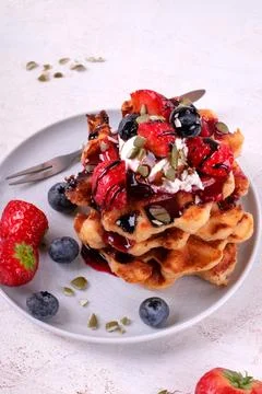 Stack of waffles with strawberry, blueberry, whipped cream and chocolate Foto stock