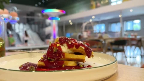 A stack of waffles topped with whipped cream and berry sauce Stock Footage 311649169