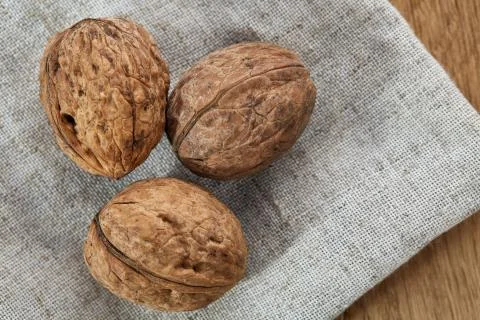 A stack of walnuts piled together and on rustic wooden background, shallow depth Stock Photos
