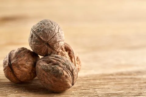 A stack of walnuts piled together and isolated on dark background, shallow depth Stock Photos