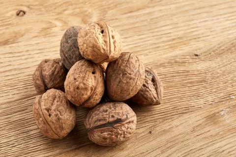 A stack of walnuts piled together and isolated on dark background, shallow depth Stock Photos