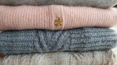Stack of warm cozy knitted women's sweaters . Autumn or winter comfort concept Stock Photos