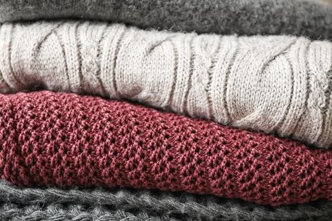 Stack of warm knitted clothes as background 스톡 사진
