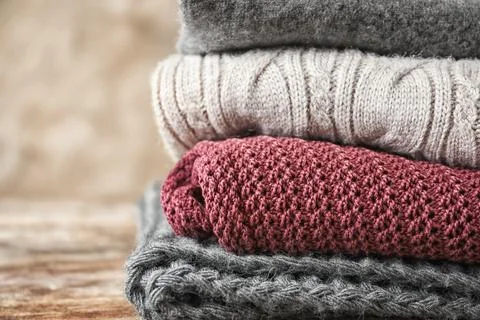 Stack of warm knitted clothes on grey background 스톡 사진