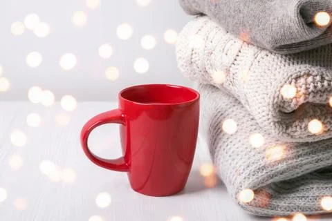 Stack of warm knitted sweaters and lights Stock Photos