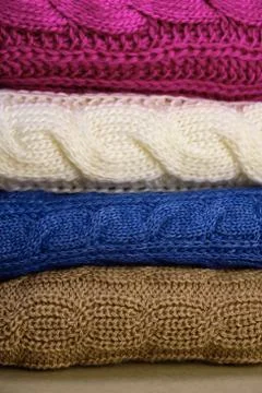 Stack of Warm knitwear close-up. Woolen knit texture as background Stock Photos
