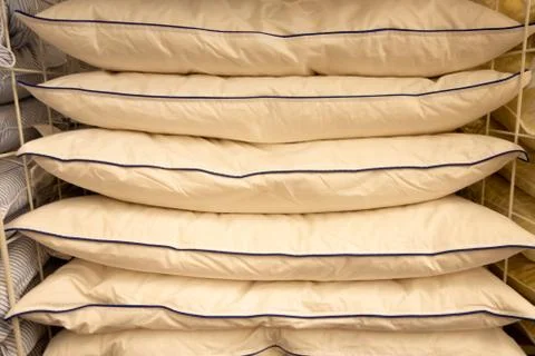 Stack of warm plaid and pillows on white shelf against striped wall backgroun Stock Photos