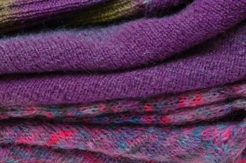 Stack of warm winter knitted sweaters. Handmade concept Stock Photos