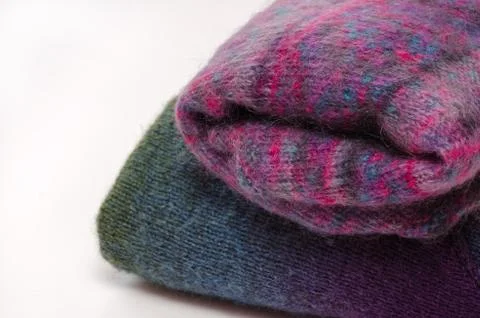 Stack of warm winter knitted sweaters on white background Stock Photos