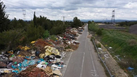 Stack of waste illegal dumping garbage over a mile along a road aerial drone 스톡 동영상 106560293