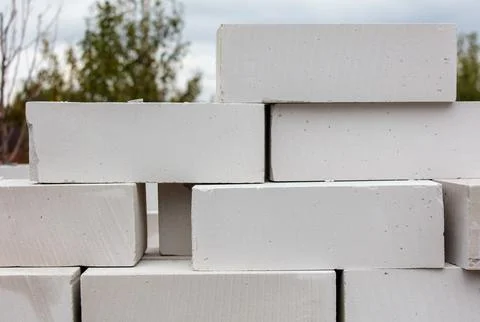 A stack of white bricks with a grey brick in the middle Stock Photos