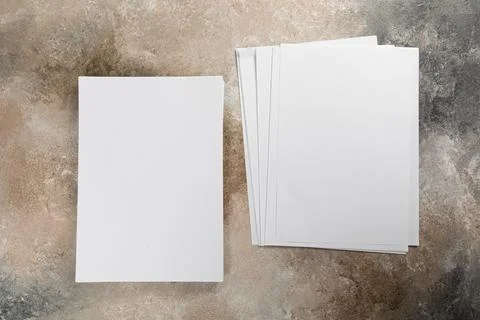 Stack of white business card sheet of paper a4 stack on grunge table. Stock Photos