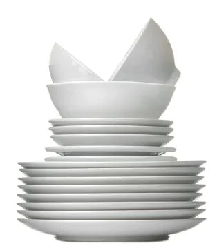 A stack of white ceramic dishes, plates, saucers, cups on a white isolated ba Stock Photos