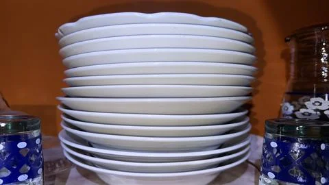 Stack of White Ceramic Plates and Bowls in a Cabinet 스톡 사진