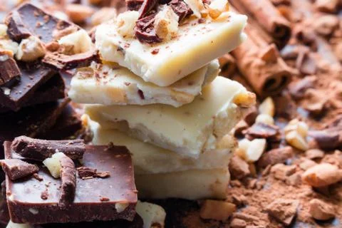 Stack of white chocolate with nuts close up on a background of cinnamon and c Stock Photos