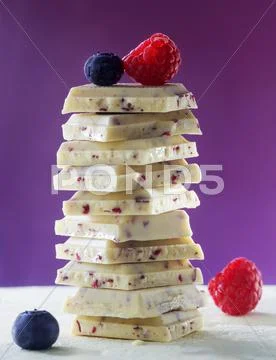 Stack of white chocolate with the raspberries and blueberries Stock Photos