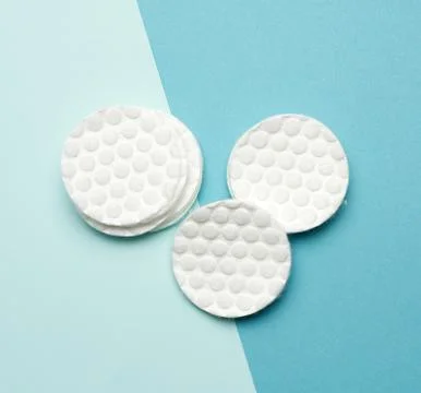 Stack of white cotton round discs for cosmetic procedures on a blue backgroun Stock-Fotos