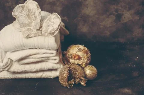 Stack of white cozy knitted sweaters on dark festive background Stock Photos