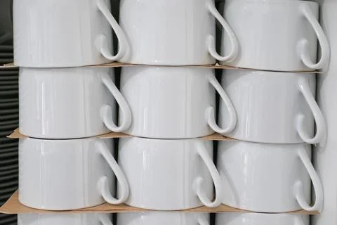 A stack of white cups with a brown paper underneath lines shapes coffee Stock Photos