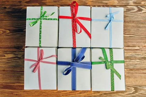 Stack of white gift boxes with ribbons on wooden table. 스톡 사진