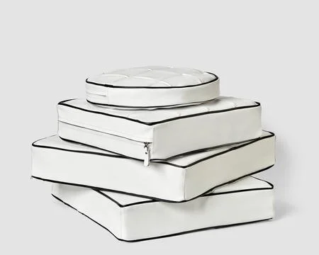 Stack of white leather floor cushions in various shapes Stock Photos