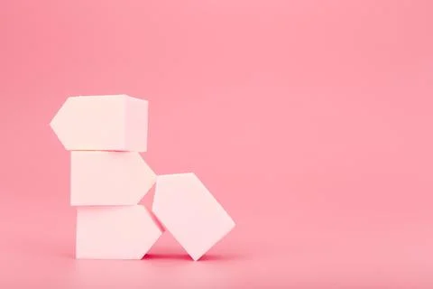 Stack of white make up sponges on pink background with copy space Stock Photos