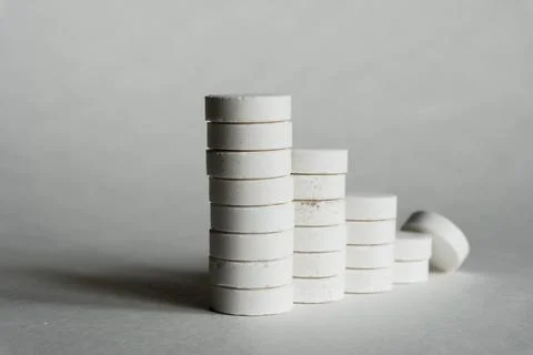 A stack of white medicine pills on white surface. Foto stock