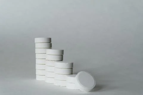 A stack of white medicine pills on white surface. Foto stock