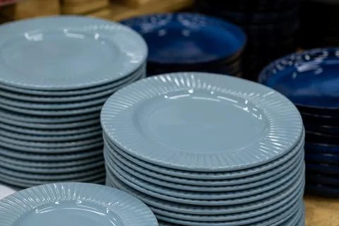 A stack of white mugs and plates in the store for sale. White and clean dishes Stock Photos