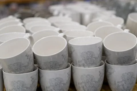 A stack of white mugs and plates in the store for sale. White and clean dishes Stock Photos