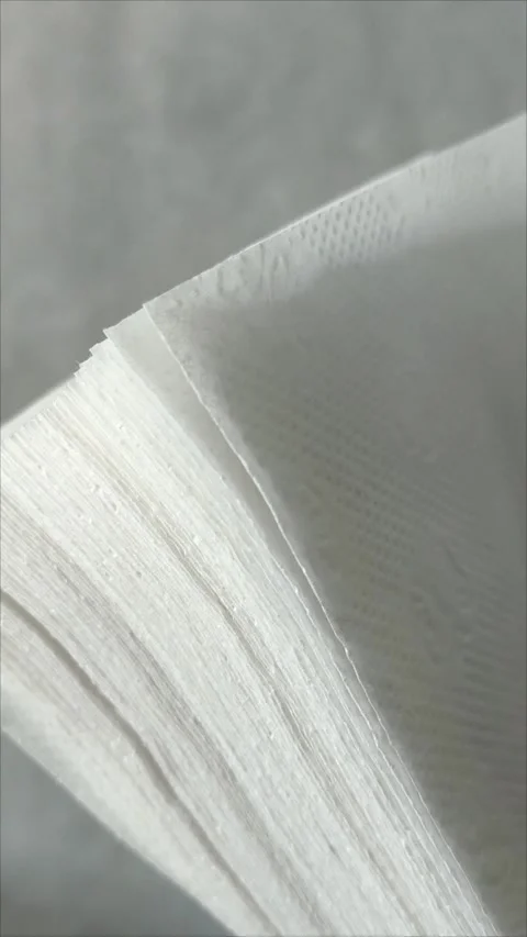 Stack white napkins in hand on white background isolation. Paper napkins with Stock Footage 313521704