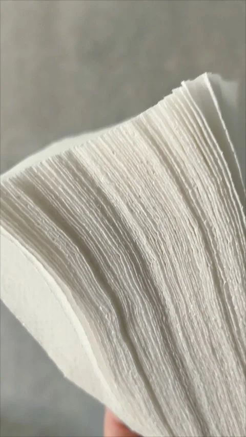 Stack white napkins in hand on white background isolation. Paper napkins with Video stock 313521734