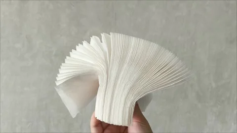 Stack white napkins in hand on white background isolation. Paper napkins with Stock Footage 313521850