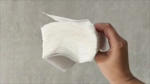 Stack white napkins in hand on white background isolation. Paper napkins with Stock Footage 313521912