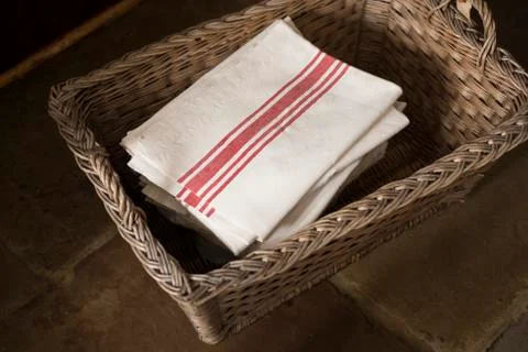 Stack of White Napkins with Red Stripes in Woven Basket Stock Photos