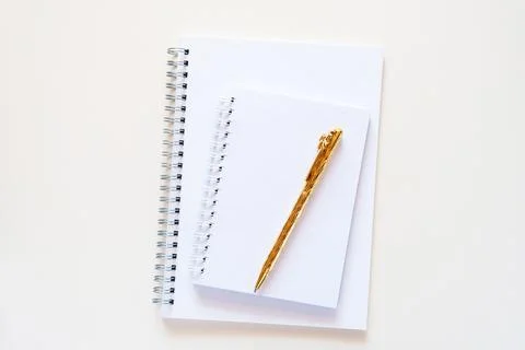 A stack of white notebooks with a spiral lie on a light brige background Stock Photos