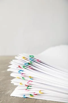 Stack of white paper with clips on grey background. Vertical foto Foto stock