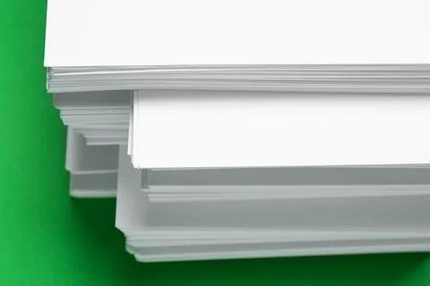 Stack of white paper on green background, closeup Stock Photos