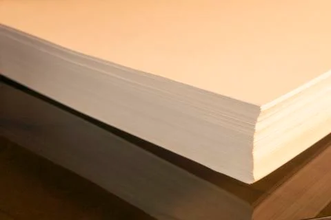 Stack of white paper rests on brown glass Stock Photos