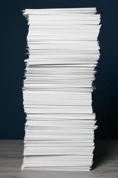 Stack of white paper sheets on blue background Stock Photos