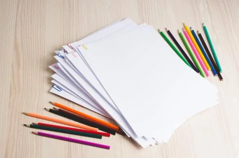 Stack of white papers and pencils with paper clips on office table Stock Photos