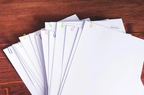 Stack of white papers with paper clips on office table Stock Photos