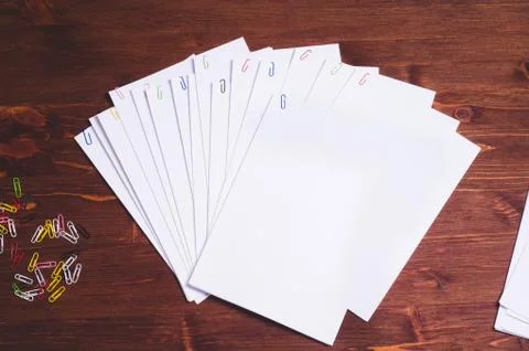 Stack of white papers with paper clips on office table Stock Photos