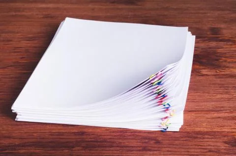 Stack of white papers with paper clips on office table Stock Photos