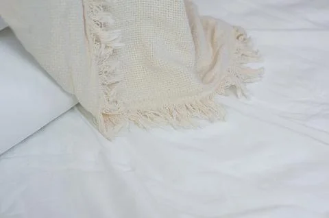 Stack of white pillows and blankets lies on the bed on a white sheet on top Stock Photos